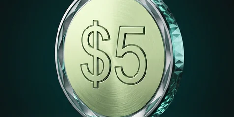 A faceted coin marked five dollars