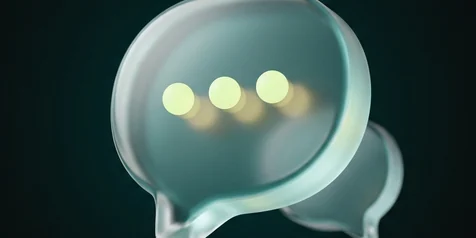 A frosted speech bubble with three glowing dots